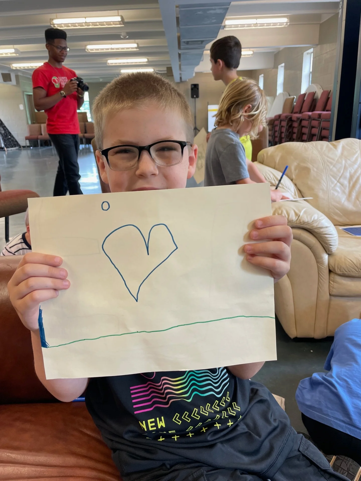 Child holding a drawing of a heart